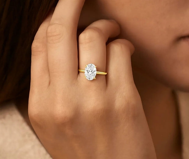 Oval solitaire diamond ring with a yellow gold band
